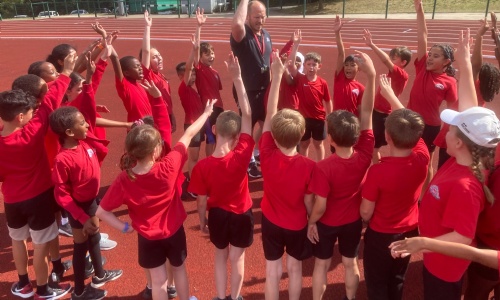 Children putting their hands up at district sports